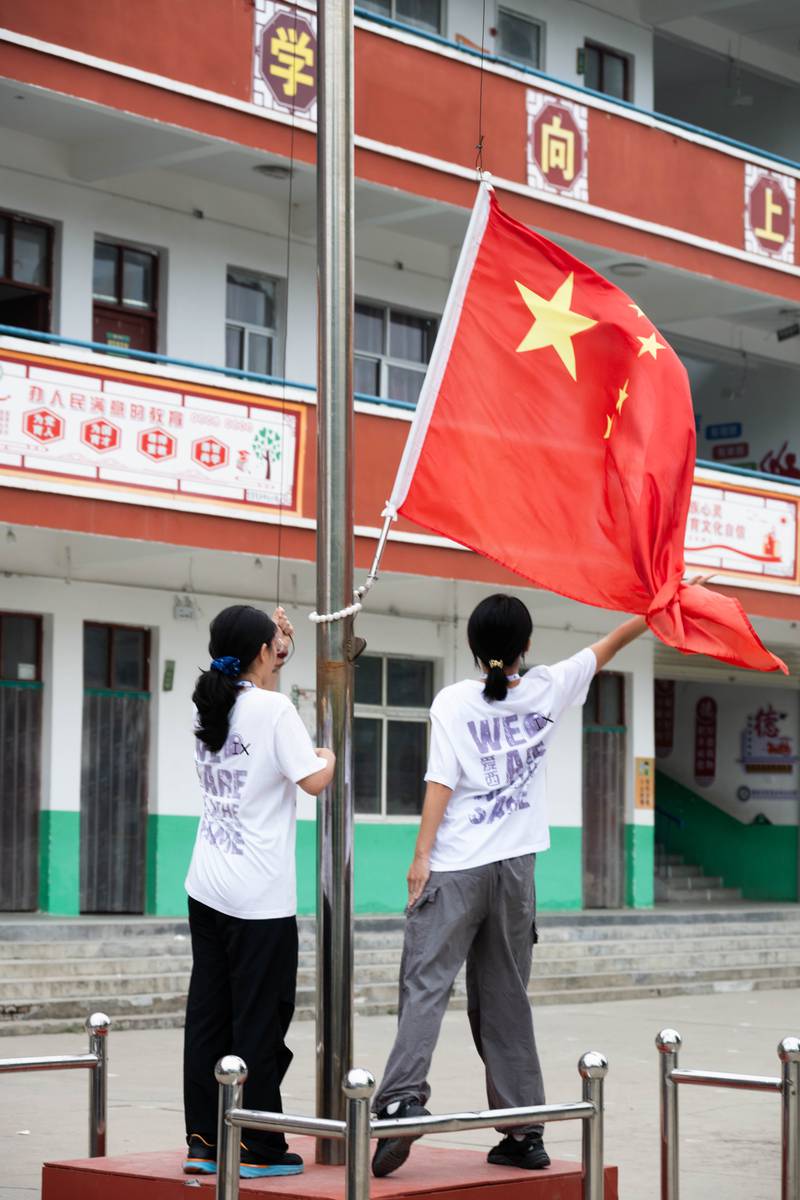 两名队员在操场上升国旗
